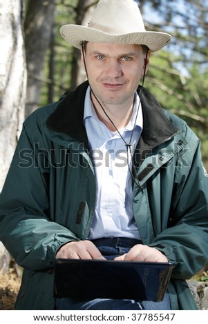 Man with laptop in forest
