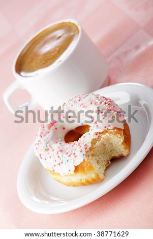 Taken a bite donut and a cup of coffee