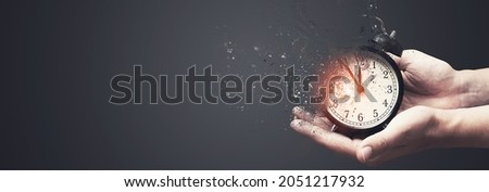 Concept of passing away, the clock breaks down into pieces. Hand holding analog clock with dispersion effect Foto stock © 
