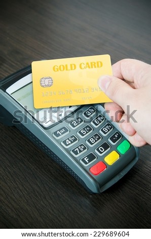 Man pays a gold card in payment terminal