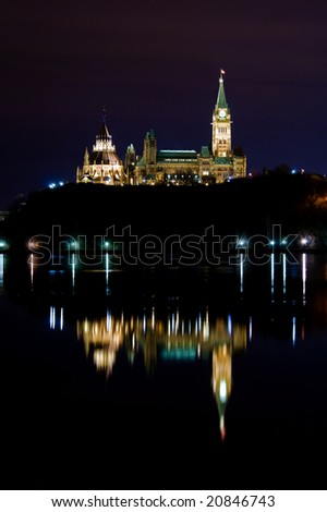 Parliament of Canada reflection in the Ottawa River at Night.  Shows the Peace Tower and the Library.