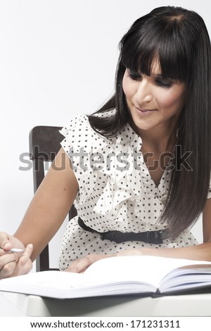 Indian Professional Woman writing remarks in diary with a pen