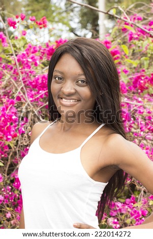 Closeup of Attractive Black woman in front of a pink bush flowers