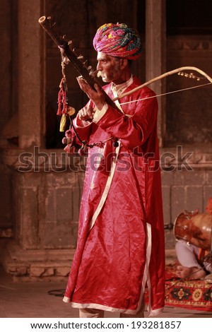 UDAIPUR, INDIA - MARCH 5: An unidentified Rajasthan performer playing sitar at a traditional theatre exposing local culture to boutique tourists in Udaipur, Rajasthan, Western India on MARCH 5, 2012.