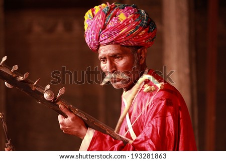UDAIPUR, INDIA - MARCH 5: An unidentified Rajasthan performer playing sitar at a traditional theatre exposing local culture to boutique tourists in Udaipur, Rajasthan, Western India on MARCH 5, 2012.