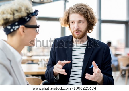 Young manager explaining his viewpoint to colleague during start-up meeting Stock foto © 