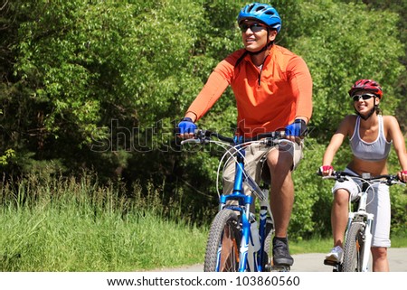 A young couple racing on bicycles in natural environment