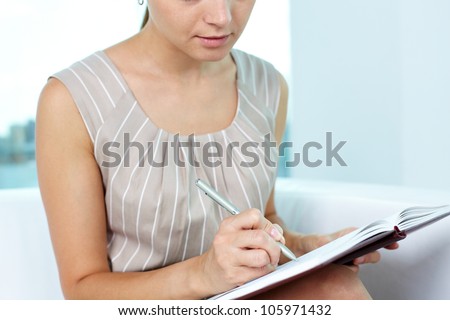 Attractive young woman taking notes in order not to forget something