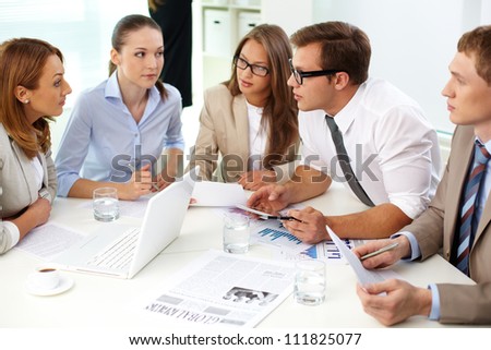 Image of confident partners looking at their colleague at meeting