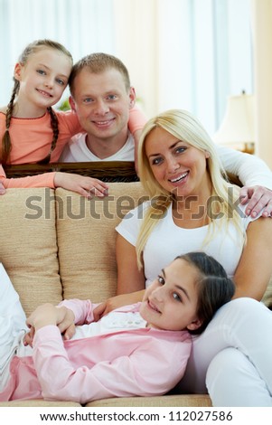 Portrait of happy couple and two daughters looking at camera