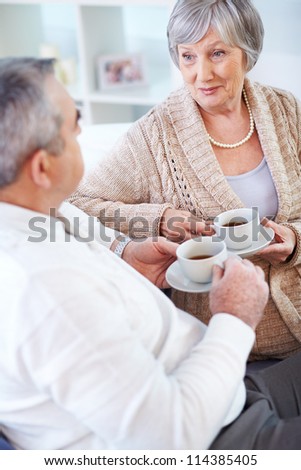 Portrait of mature man and his wife drinking tea and interacting