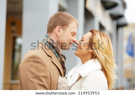 Portrait of affectionate couple touching by their noses in urban environment