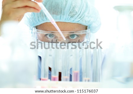 Chemist testing sample of liquid in laboratory