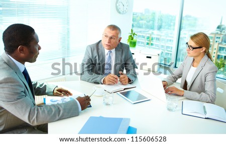 Portrait of serious boss talking and his employees listening to him