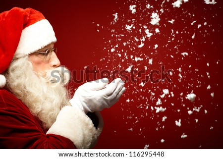 Photo of Santa Claus blowing snow and looking at it