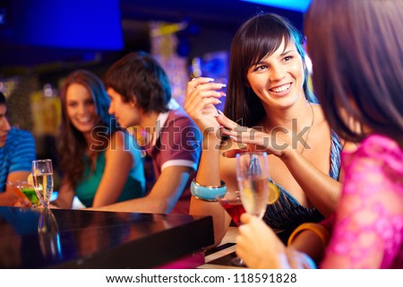 Portrait of pretty girls talking at party in the bar