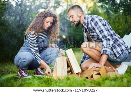 Similar – Foto Bild Paar mit Brennholz beim Lagerfeuermachen im Wald