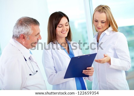 Portrait of successful medical workers discussing plan in hospital