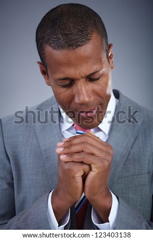 Smart businessman praying with his eyes closed