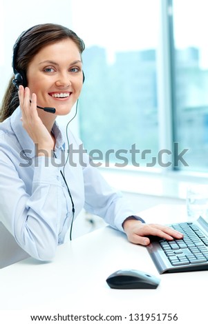 Portrait of young operator with headset looking at camera with friendly smile