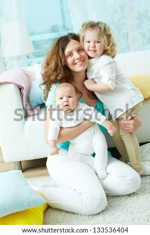 Vertical portrait of a happy family of three looking at the camera
