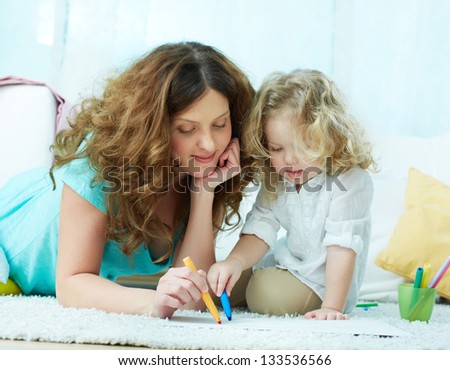 Close-up image of a lovely mom drawing with her little daughter