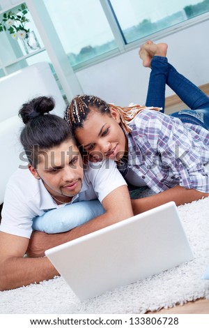 Image of young guy and his girlfriend using laptop at home
