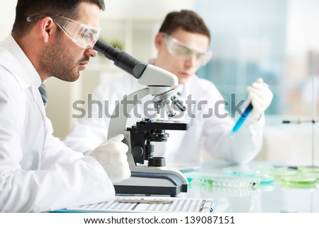 Similar – Image, Stock Photo Serious clinician studying chemical element in laboratory