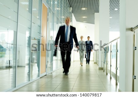 Businesspeople going along corridor inside office building