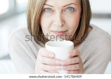 Portrait of mature woman with cup looking at camera
