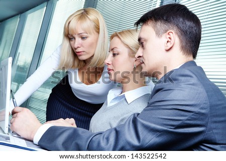 Three business people discussing project at meeting
