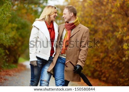 Portrait of affectionate couple taking a walk in autumnal park