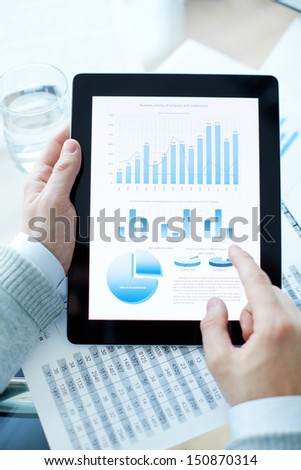 Hands of businessman holding touchpad with electronic document