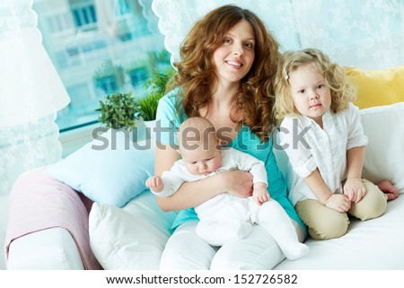 Portrait of a happy mother resting with her two kids at home