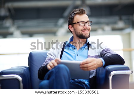Smart businessman with touchpad thinking of new idea or strategy in office