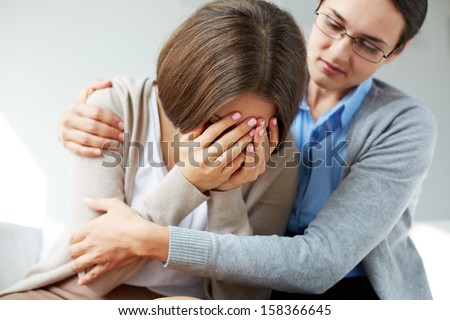 Image of compassionate psychiatrist comforting her crying patient