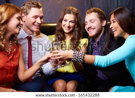 Group of friends toasting with flutes of champagne in the bar