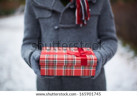 Image of gloved hands of guy holding Christmas present