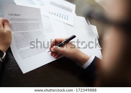 Image of businessman hand with pen signing contract