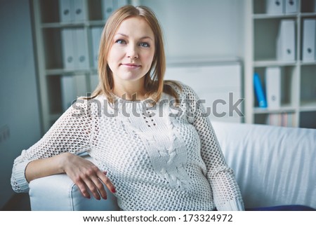 Calm girl in casual clothes looking at camera inside