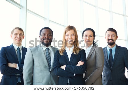 Group of business partners looking at camera with smiles, pretty leader in front