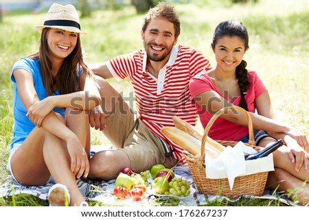 Happy young friends having picnic in the country
