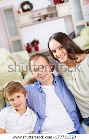 Portrait of happy family of three looking at camera