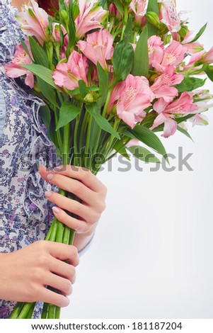 Close-up of bunch of pink lilies in female hands