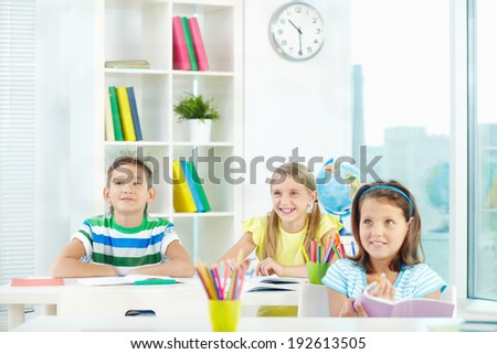Portrait of happy classmates at workplace during lesson