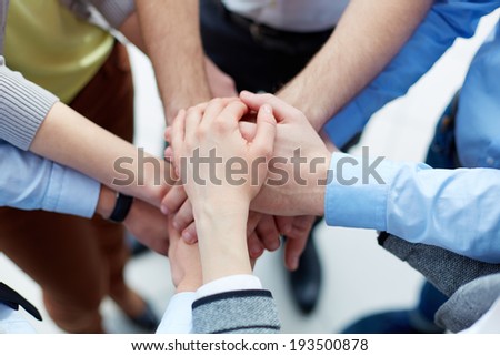 Business partners hands on top of each other symbolizing companionship