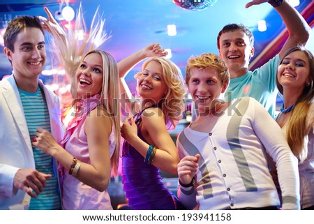 Portrait of cheerful girls and guys dancing at party