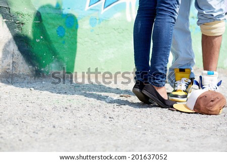 Image of young couple legs on background of graffiti wall