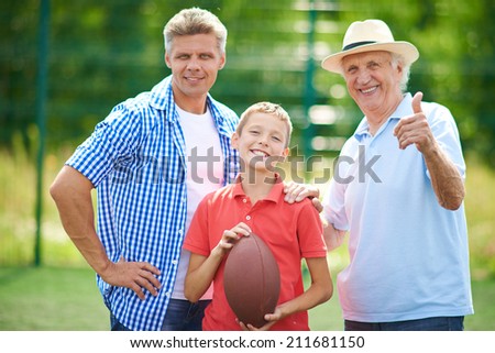 Portrait of three males with rugby ball