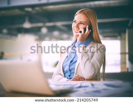 Young businesswoman calling on the phone in office